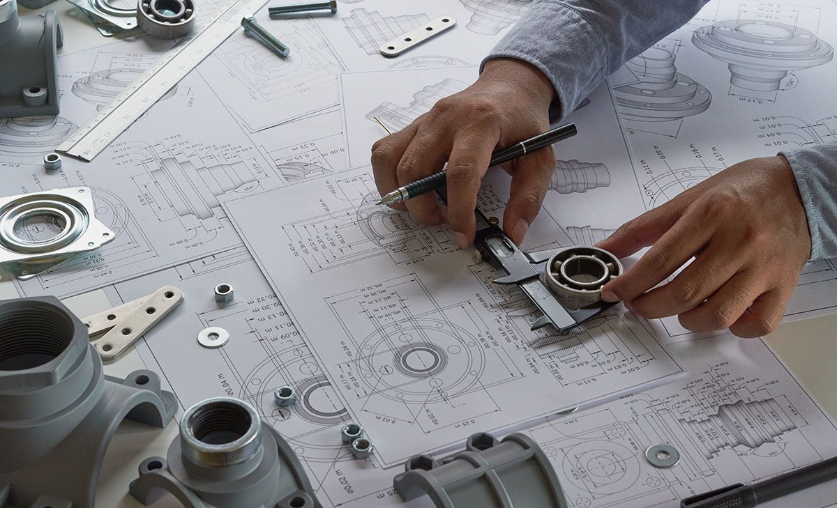 Engineer technician designing drawings mechanical parts engineering Engine<br />
manufacturing factory Industry Industrial work project blueprints measuring bearings caliper tools